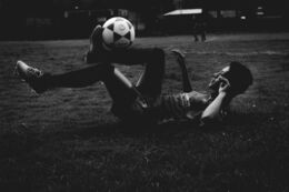 Fodboldspiller jonglerer med bolden - sort hvid foto